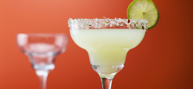 Essence Margarita Glasses

1 Essence Margarita Glass filled with a lemon cocktail and garnished with a lime slice on the rim of the glass and the rest of the rim is coated in salt. The glass is placed on a wooden board which is accompanied with whole chilli peppers and sliced chilli, as well as, 2-quarter slices of lime. 1 Essence Margarita Glass in the background.